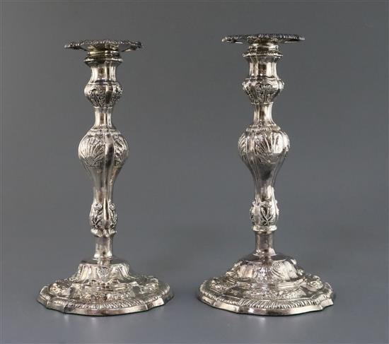 A pair of late George II embossed silver candlesticks, by William Tuite, weighted.